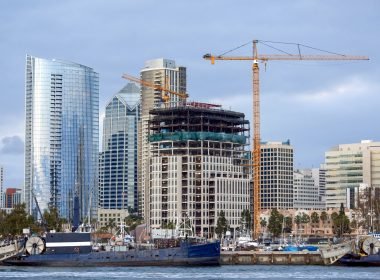 Construction works and high, modern buildings, yachts and two old moored boats on the foreground in San Diego, USA